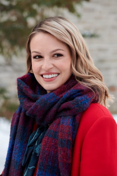 Taylor dans un manteau rouge avec une écharpe festive