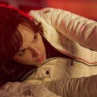 Rachel Stone lies on the ground firing her weapon in Heart of Stone