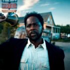 Harold Perrineau as Boyd Stevens rings a bell in front of a dilapidated motel in From