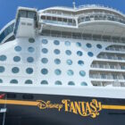 Side of the Disney Fantasy docked at port.