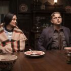 Mollie looks at Ernest as they sit at a dining table in Killers of the Flower Moon