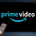 An image of the Prime Video logo on a TV with someone watching it