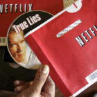 File - Mei Michelson prepares to watch a Netflix DVD at her home in Palo Alto, Calif., on Oct. 22, 2007. The Netflix DVD-by-service will mail out its final discs Friday from its five remaining distribution centers, ending its 25-year history. (AP Photo/Paul Sakuma, File)