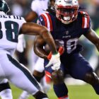 New England Patriots running back Rhamondre Stevenson carries the football while facing Philadelphia Eagles defender Michael Jacquet