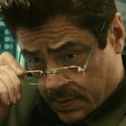 Tom Nichols looks down at something from underneath his glasses in Netflix