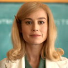 Brie Larson as Elizabeth Zott wearing a lab coat and standing in front of a chalkboard in Apple TV Plus' Lessons in Chemistry