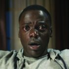 A close up of a teary eyed Chris sitting in a chair in Get Out