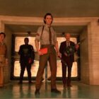 a group of people stand in front of double bars inside building