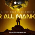 Still from the T.V. show For All Mankind (season 4, episode 1). Silhouette of an astronaut miner holding a pick axe whilst standing on a large rock. Above them is the show title 