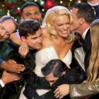 Male performers surround a female singer in formal dress.