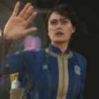 Lucy emerges from Vault 33 with her right hand raised in Amazon