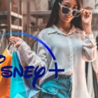A woman holding shopping bags with the Disney+ logo