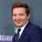 Jeremy Renner smiles in a blue suit.