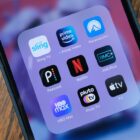 A grid of streaming service apps (Sling, Prime Video, Paramount Plus, Peacock, Netflix, AMC Plus, HBO Max, Pluto TV, Apple TV) open on a phone