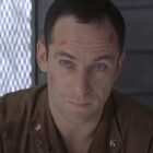 Jason Isaacs sits with scrapes and a look of concern in Event Horizon.