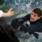 Ethan Hunt (Tom Cruise) hangs from a helicopter above a valley 