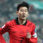 Son Heung-min, wearing a red and black South Korea soccer shirt, warms up for the AFC Asian Cup in Qatar.