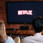 Couple watching Netflix logo on TV