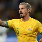 Jamie Maclaren of the Socceroos in yellow shirt points on the pitch ahead of the AFC Asian Cup Australia vs India live stream 