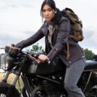 woman with backpack sits on motorcycle