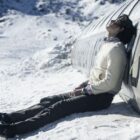Enzo Vogrincic Rold&aacute;n as a despondent Numa Turcatti sitting on a snowy mountaintop against the crashed remains of a commercial airplane in Society of the Snow