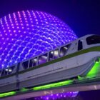 Spaceship Earth lit up at night behind momorail