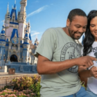A couple of Guests using Disney Genie+ in front of Cinderella Castle at Disney World