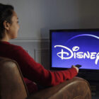 Woman sitting in front of Disney+ screen