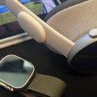 Apple Watch Ultra with a khaki band next to Apple Vision Pro on a desk.