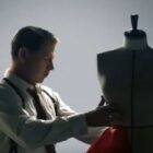 A man works with a dress-form mannequin.