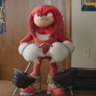 A sonic the hedgehog mascot is standing in a room.