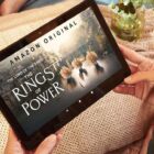 A woman holds a tablet with Prime Video on the screen
