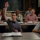 Sheldon Cooper (Iain Armitage) with his hand raised in a classroom in Young Sheldon