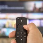 Man holding a remote in front of a TV