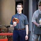 Sheldon Cooper (Iain Armitage) eating a pretzel outside a German cafe in 