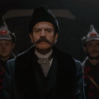 Ewan McGregor as the fictional Count Alexander Ilyich Rostov with a luxuriant mustache and looking unhappy as he is flanked on both sides by Russian soldiers 