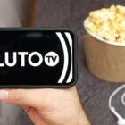 Pluto TV on a phone with popcorn nearby