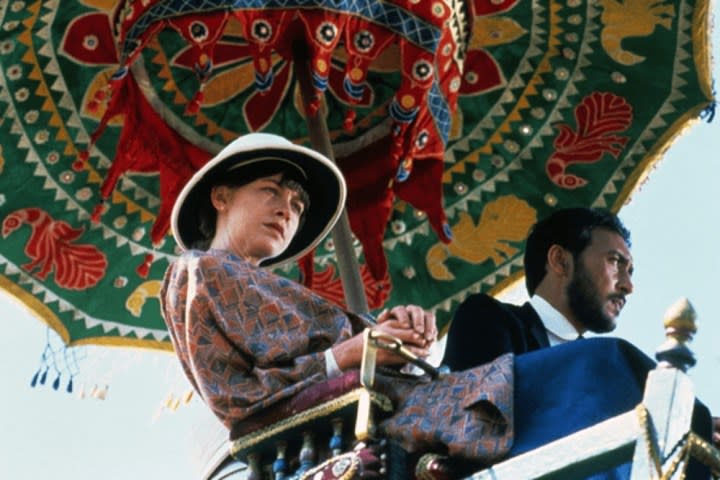 Une femme et un homme montent un éléphant dans A Passage to India.