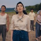 A group of farmers look on at something happening off camera in Pachinko season 2 on Apple TV Plus