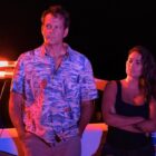 Andrew and Rosa stand in front of a cop car at night in Apple