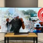 65-inch LG C4 TV on a wooden stand. A golfer is being sprayed with champagne on the screen.