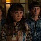 The main characters look onwards, concerned, in a 