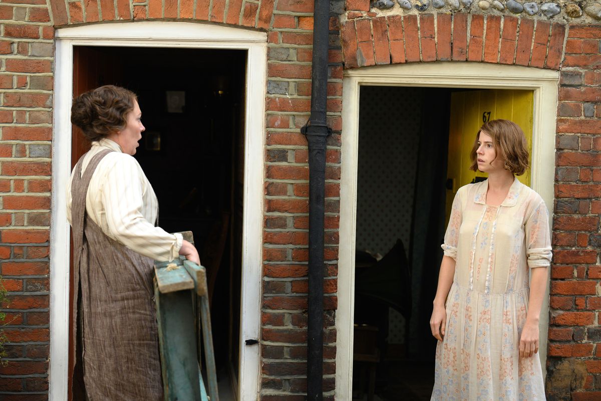 Les voisines de rangée Edith (Olivia Colman) et Rose (Jessie Buckley) se font face devant leurs portes d'entrée côte à côte dans Wicked Little Letters