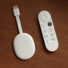Chromecast with Google TV dongle next to remote 