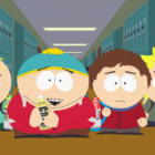 Four cartoon children stand in a school hallway in front of lockers. The child in the center holds an item in their hands.