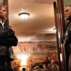 Brad Pitt and George Clooney stand either side of a doorway in Apple TV Plus original movie, 'Wolfs'