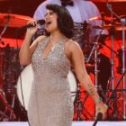 RAYE performs onstage in a glittery silver dress ahead of her performance at the 'American Music Awards' 2024