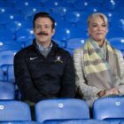 Ted Lasso and Rebecca Walton sit in the stands in Ted Lasso