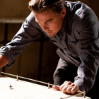Leonardo DiCaprio as Cobb, looking at his spinning top totem in Inception