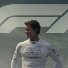 Brad Pitt looks over his right shoulder with 'F1' written behind him 